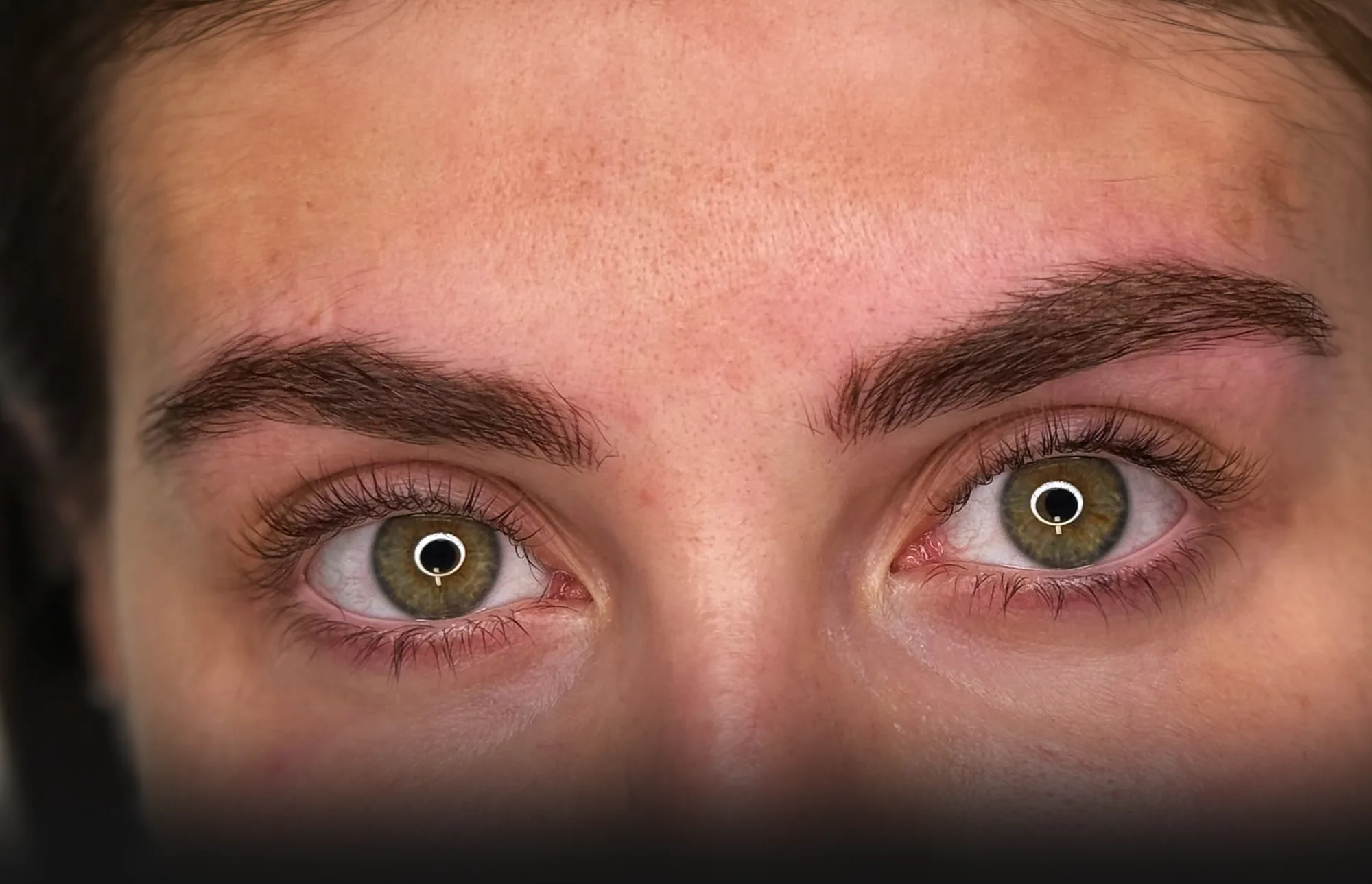 Primo piano di occhi con sopracciglia folte e naturali, ridisegnate con la dermopigmentazione
